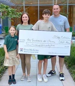Ayden holding donation check with family